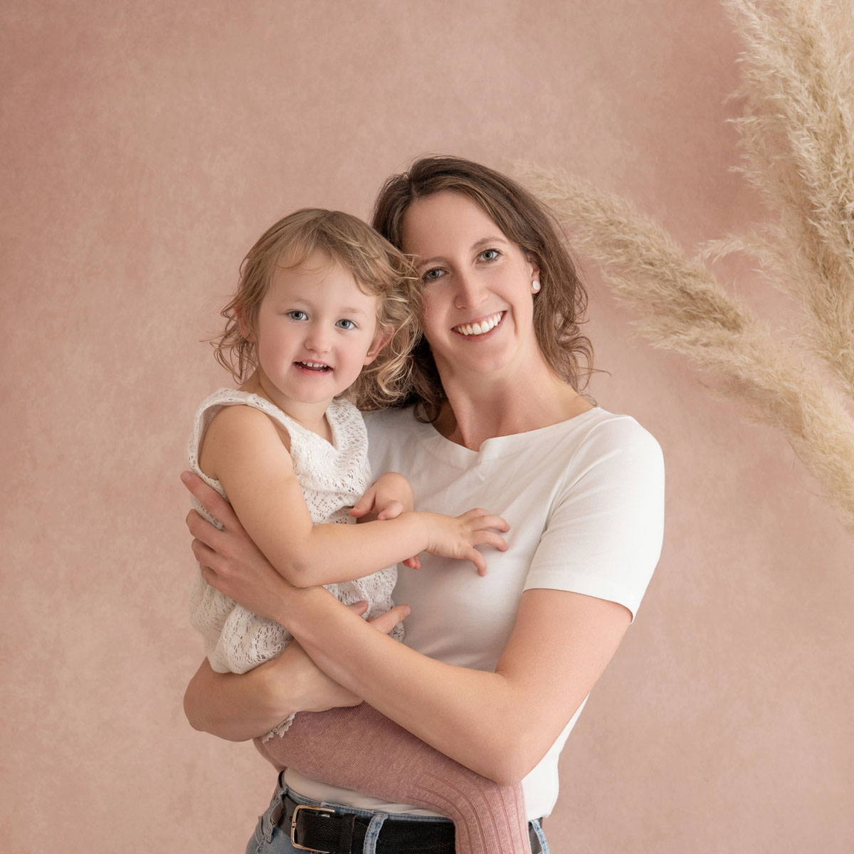 Mama hält ihre kleine Tochter lachend im Arm