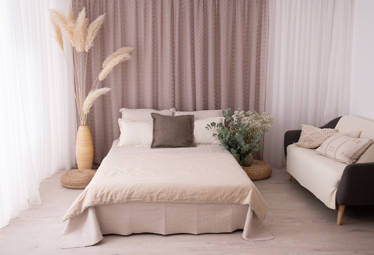 Fotostudio mit großem Bett, Pampasgras und einem bequemen Sofa für Eltern und Geschwister