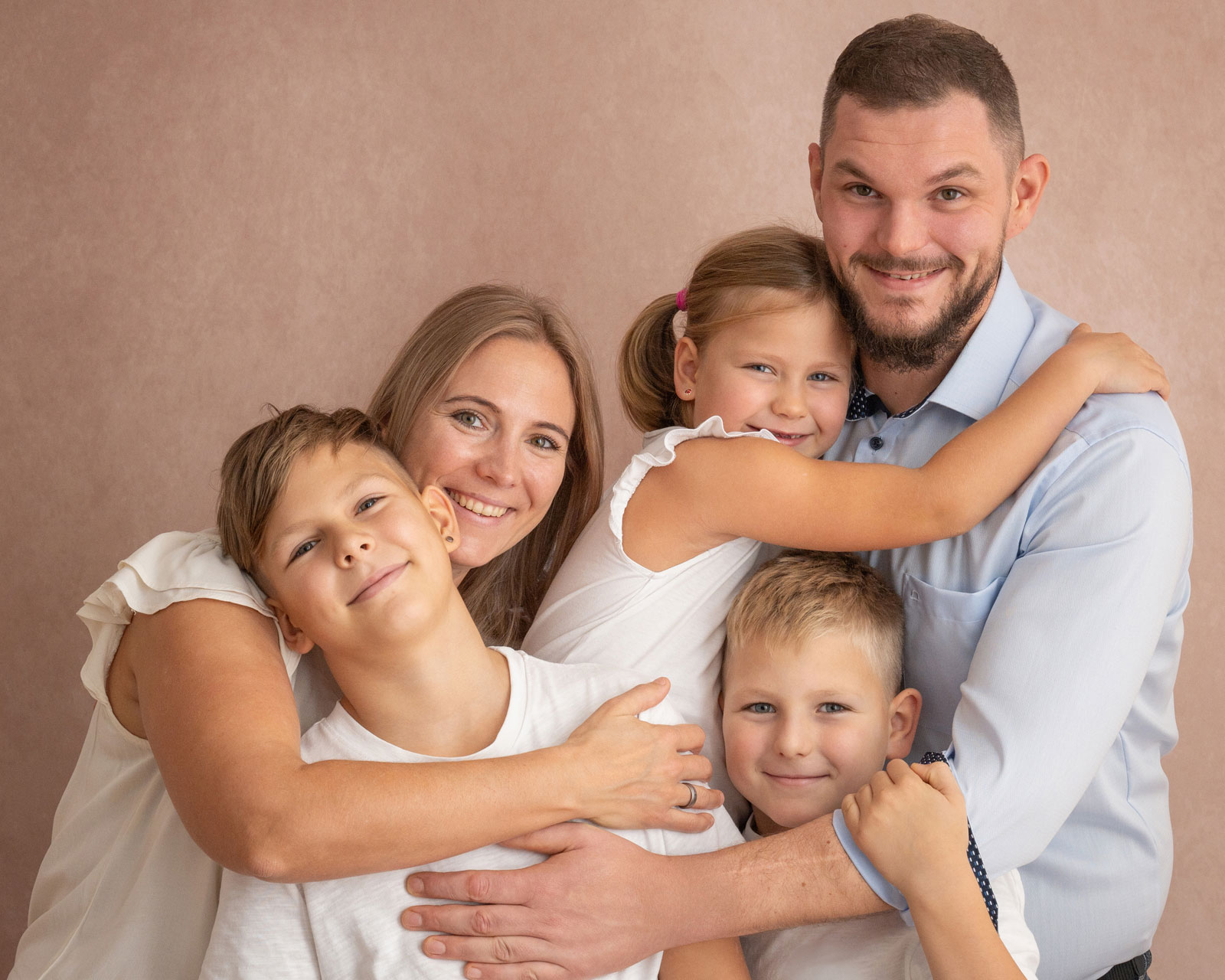Lachende Familie mit Kindern beim Familienshooting